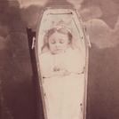 Girl in propped-up coffin